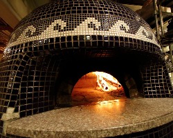 ピッツァは薪窯で丁寧に焼き上げます。
