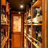 ご自分でもお好きな1本が選べるワインの陳列棚を通路両壁に設置