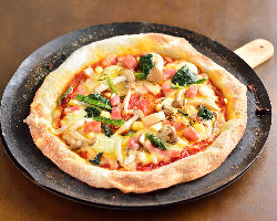 注文を受けてから焼き上げるピザは野菜たっぷりの薄焼きタイプ。